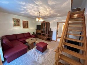 un soggiorno con divano rosso e una scala di Penzión Odysea a Vinné