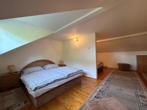 ein Schlafzimmer mit einem großen Bett im Dachgeschoss in der Unterkunft Penzión Odysea in Vinné