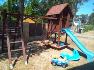 un parque infantil con tobogán y columpio en Muszla en Pobierowo