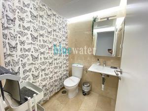 een badkamer met een toilet, een wastafel en een spiegel bij El Salon, Nerja BLUEWATER VILLAS in Nerja