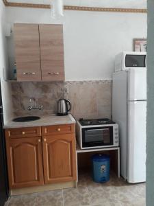 a small kitchen with a microwave and a refrigerator at LenNy 2 in Kranevo +9 photos