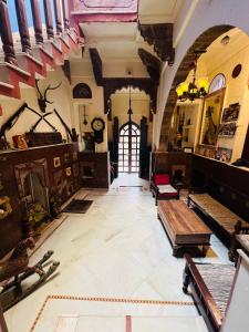 a large room with a table and benches in it at Juna Mahal Boutique Home Stay in Jodhpur
