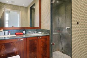 ein Bad mit einer Dusche und einem Waschbecken in der Unterkunft Three Bedroom Apartment in Sloane Square in London