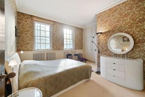 ein Schlafzimmer mit einem großen Bett und einem Spiegel in der Unterkunft Three Bedroom Apartment in Sloane Square in London