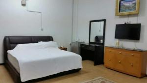 a bedroom with a bed and a dresser with a mirror at DamaiSari Tawang in Bachok