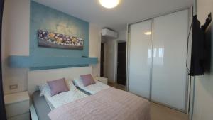 1 dormitorio con cama y pared en Bella Vista Apartments, en Umag
