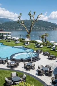 uma piscina com mesas e cadeiras junto à água em Grand Hotel Dino em Baveno