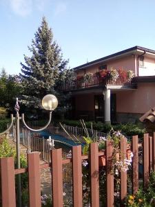 a fence in front of a house with a tree at L’agrifoglio in Francavilla in Sinni