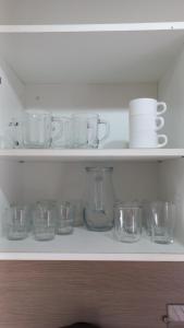 a shelf with glass bowls and plates on it at Bungalow T3 Renata in Burinhosa