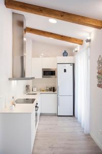 a kitchen with white cabinets and a white refrigerator at Lovely and bright apartment in the heart of Banyoles in Banyoles