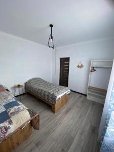 a room with two beds in a room with wooden floors at Бэй Хаус ( The Bay Area) in Cholpon-Ata