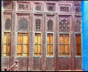 eine Gruppe von Fenstern auf einem Gebäude mit Holz in der Unterkunft Juna Mahal Boutique Home Stay in Jodhpur