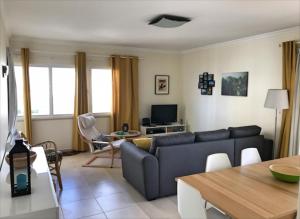 uma sala de estar com um sofá e uma mesa em Varandas Do Sol 2 em Portimão