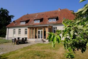 a white house with a table and chairs at Gutshaus FeWo Priwall in Dassow