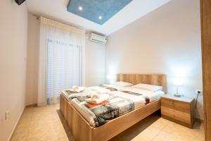 sypialnia z łóżkiem w pokoju z oknem w obiekcie Milonas House Apartments w mieście Paralia Dionisiou