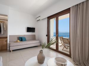 uma sala de estar com um sofá e vista para o oceano em Porto Kaza em Sitia