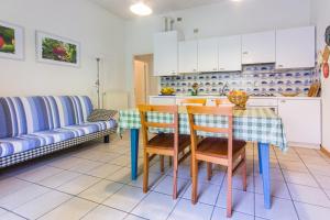 cocina con mesa, sillas y sofá en Casa Irina, en Riva del Garda