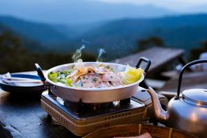 a pot of food on a stove with a salad at JADAE HOUSE Doichang in Ban Huai Khai