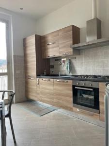 uma cozinha com armários de madeira e um fogão em Casa vacanza Le Cinque Terre em La Spezia