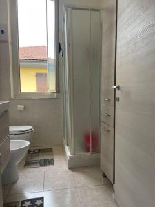 uma casa de banho com um WC e uma porta de duche em vidro. em Casa vacanza Le Cinque Terre em La Spezia