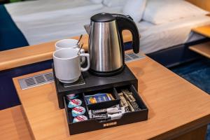 a tray with a coffee pot and cups on a table at Hotel Hanseport Hamburg in Hamburg