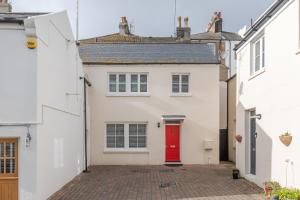a white house with a red door at Beachfront Getaway 2-Bedroom House with FREE Private Parking & Patio in Brighton & Hove