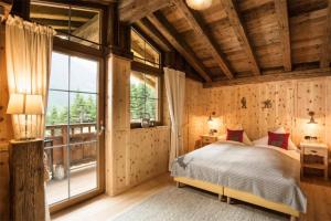 sypialnia z łóżkiem i dużym oknem w obiekcie Gletscher-Chalet Stubai w Neustift im Stubaital