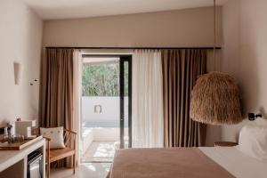 a bedroom with a bed and a sliding glass door at GAIA Alaçatı BY THE SEA - Adult Only in Cesme