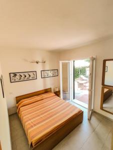 um quarto com uma cama e uma porta de vidro deslizante em Appartamento Bellavista em Cavo