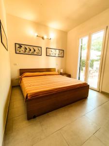 a large bed in a bedroom with a large window at Appartamento Bellavista in Cavo