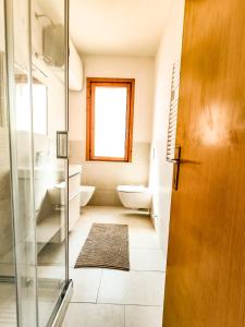 a bathroom with a toilet and a glass door at Appartamento Bellavista in Cavo