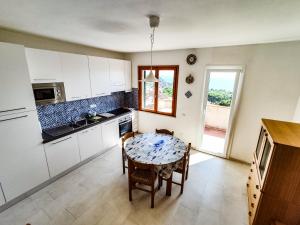 kuchnia ze stołem i krzesłami w obiekcie Appartamento Bellavista w mieście Cavo +3 zdjęcia
