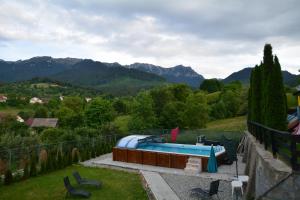 a swimming pool on a patio with mountains in the background at Pensiunea Antonia in Bran