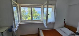 a small bedroom with a bed and a window at Simple beachfront rooms Bego in Kraljevica