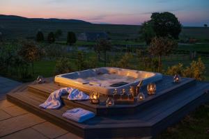 jacuzzi na tarasie z oświetleniem w obiekcie Kipney Farmhouse - luxury hunting lodge w mieście Perth