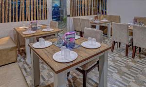 a dining room with wooden tables and chairs at Treebo Trend Seven Inn in Tirupati