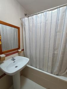 La salle de bains blanche est pourvue d'un lavabo et d'une douche. dans l'établissement APTO NERE PLAYA, à Santa Pola