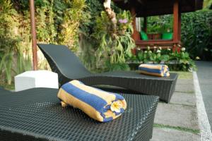 two pillows sitting on top of a black chair at Pondok Sebali Private Villa in Ubud