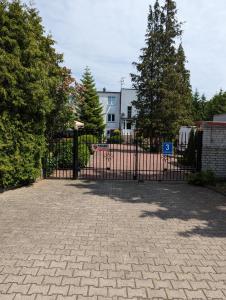 una puerta de hierro negra en una entrada con árboles en Pokoje gościnne Simon, en Mielno