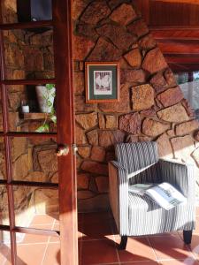 a chair in front of a stone wall at Karriview in Gracetown