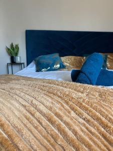 Una cama con dos almohadas azules encima. en Appartement de charme 80m2, en Givors