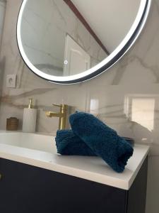 lavabo con espejo y toalla azul en Appartement de charme 80m2, en Givors