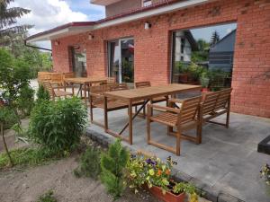 Une table et des chaises en bois sont disponibles sur la terrasse. dans l'établissement Gościniec Celina, à Krasnobród