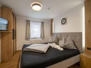 a bedroom with a bed with a black and white comforter at Appartement Mayrl in Fieberbrunn