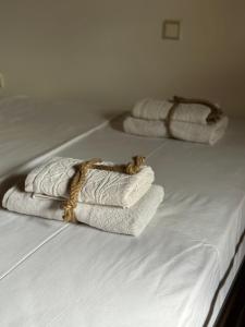 zwei Stapel Handtücher auf dem Bett in der Unterkunft Elena maisonette by the sea in Kamena Vourla
