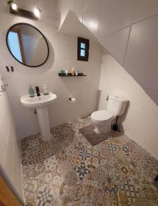 een badkamer met een wastafel, een toilet en een spiegel bij Apartamentos Entreteatros, fantástico duplex casco histórico in Talavera de la Reina