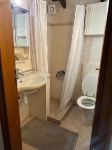 a small bathroom with a toilet and a sink at Elena maisonette by the sea in Kamena Vourla
