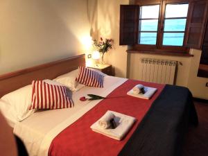 a bedroom with a bed with towels and a window at Villa Panorama in Montecatini Val di Cecina +21 photos