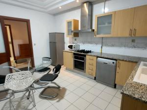 a kitchen with a table and chairs in it at FLAT JINEN DU LAC 2 in Tunis +24 photos