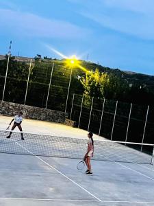 two people playing tennis on a tennis court at Casuta Pescarului 